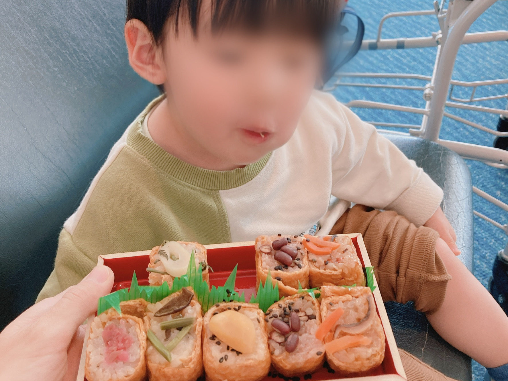 空港ロビーで空弁を食べる息子